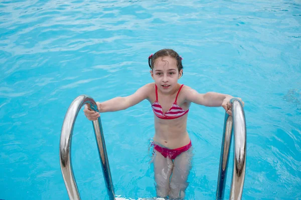Egy kislány pihen a nyáron az Aqua parkban. baba úszik a medencében. — Stock Fotó