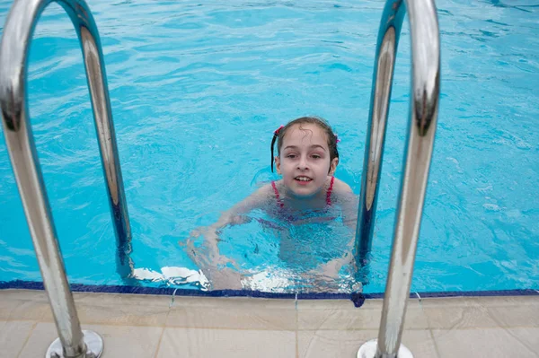 Egy kislány pihen a nyáron az Aqua parkban. baba úszik a medencében. — Stock Fotó