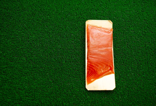 .salted salmon fish on green grass. fish salmon in the package. — Stock Photo, Image