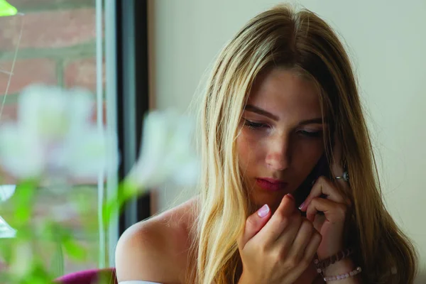 Eine schöne junge blonde Frau am Telefon. — Stockfoto