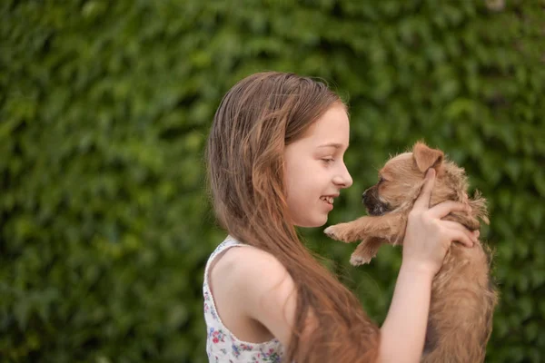 Uma menina loira com seu cão de estimação outdooors no parque. — Fotografia de Stock