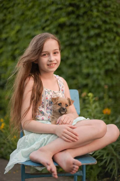 Una niña rubia con su perro mascota en el parque. — Foto de Stock