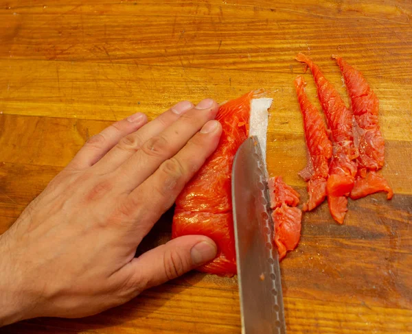 Fresh salmon and knife on cutting board on the wooden table. Top view. — Stock Photo, Image
