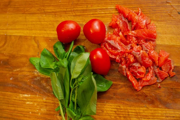 Fresh red salmon fish cut on wooden board. Green basil.Red tomatoes. Good food. — Stock Photo, Image