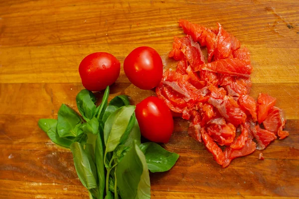 Pesce salmone rosso fresco tagliato su tavola di legno. Basilico verde.Pomodori rossi. Buon cibo . — Foto Stock