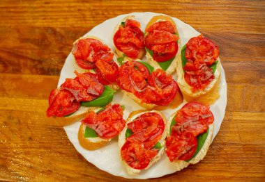 Tahta tahtada kesilmiş taze kırmızı somon balığı. Yeşil fesleğen. Kırmızı domates. Yaz sandviçleri. İyi yemek.