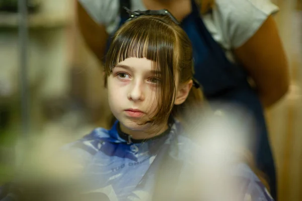 Перукар робить зачіску милою маленькою дівчинкою — стокове фото