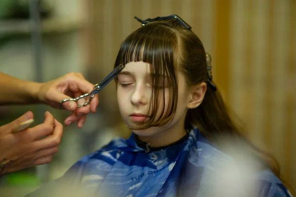 Fryzjer podejmowania fryzurę do cute little girl — Zdjęcie stockowe