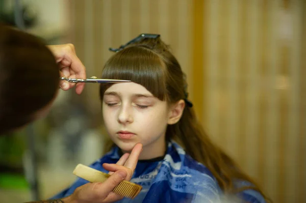 可愛い女の子にヘアスタイルを作る美容師 — ストック写真