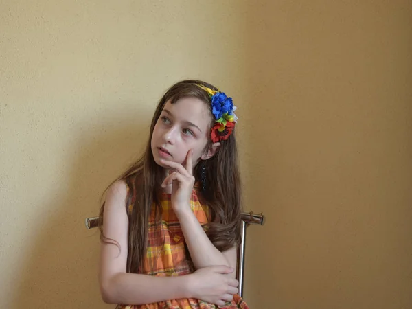 Маленькая девочка с седыми глазами и светлыми волосами сидит на стуле — стоковое фото