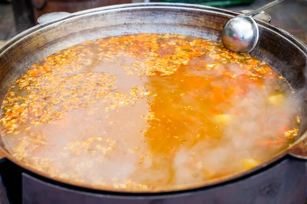 Főzés egy nagy bogrács keleti ételek-leves leves zöldségekkel és hússal. — Stock Fotó