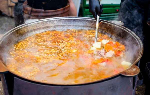 Főzés egy nagy bogrács keleti ételek-leves leves zöldségekkel és hússal. — Stock Fotó