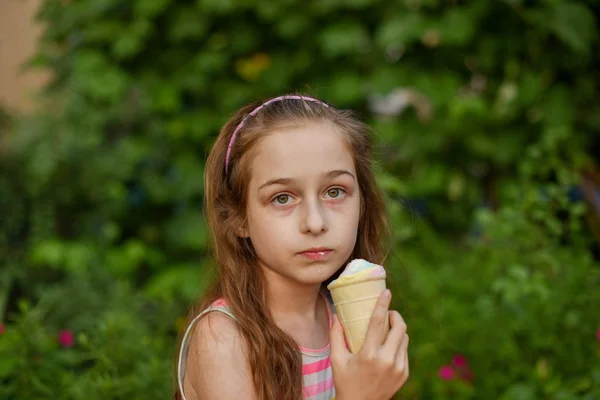 Niña comer helado al aire libre En un vestido brillante a rayas de colores. Soleado verano, clima caluroso . —  Fotos de Stock