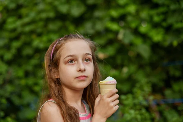 Niña comer helado al aire libre En un vestido brillante a rayas de colores. Soleado verano, clima caluroso . —  Fotos de Stock