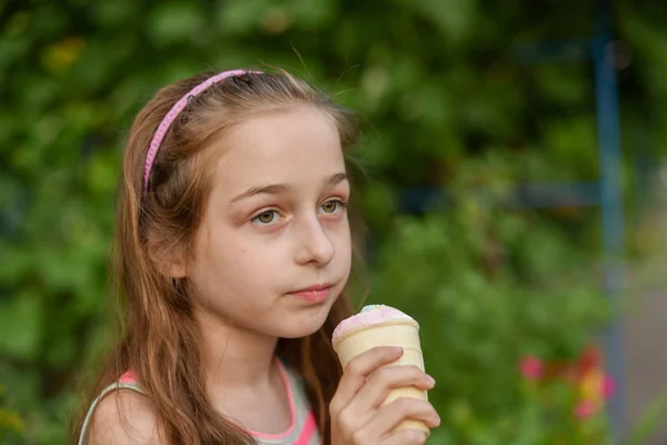 Niña comer helado al aire libre En un vestido brillante a rayas de colores. Soleado verano, clima caluroso . —  Fotos de Stock