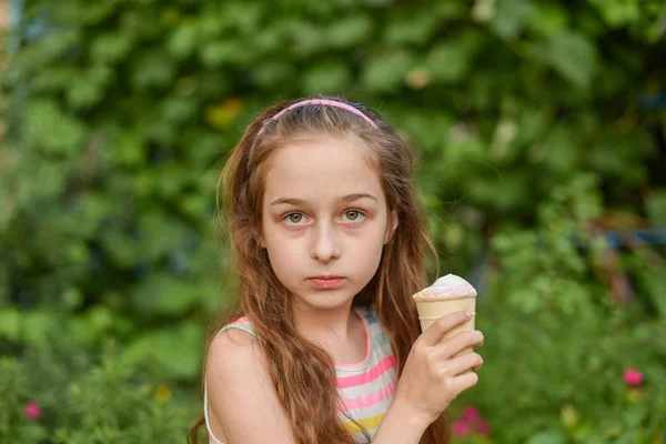 Niña comer helado al aire libre En un vestido brillante a rayas de colores. Soleado verano, clima caluroso . —  Fotos de Stock