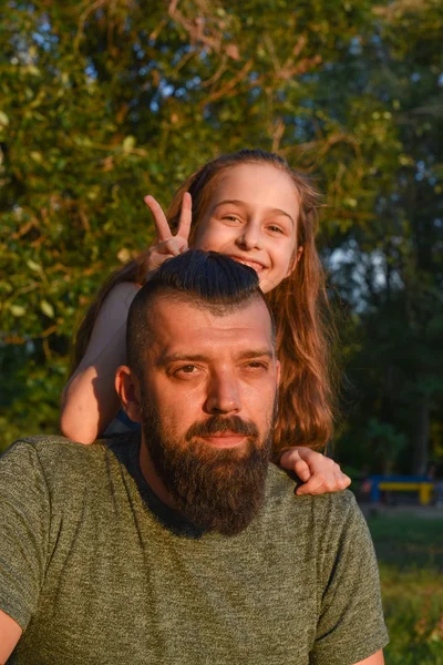 Family time. Little girl hugging her dad with a beard. Summer walk