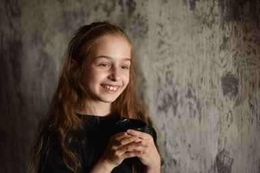 Elinde siyah tişörtlü kahve fincanı tutan küçük bir kız. Tasarımınızı ortaya koymak için mükemmel, alay edin.