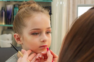 sahnede sahne almadan önce makyaj yapan küçük bir kız. Soyunma odasında performans öncesi hazırlık