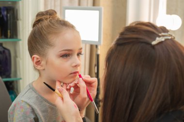 sahnede sahne almadan önce makyaj yapan küçük bir kız. Soyunma odasında performans öncesi hazırlık