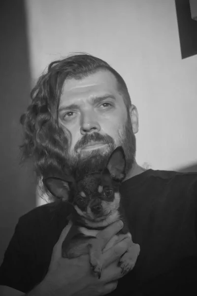 一个留着胡子的男人拥抱一只小狗品种奇瓦瓦. — 图库照片