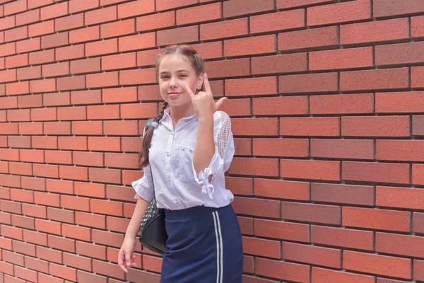 Primer plano retrato de pequeña niña hermosa y elegante cerca de la pared de ladrillo rojo como fondo — Foto de Stock