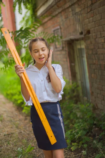 Elementary schoolgirl standing by school gate