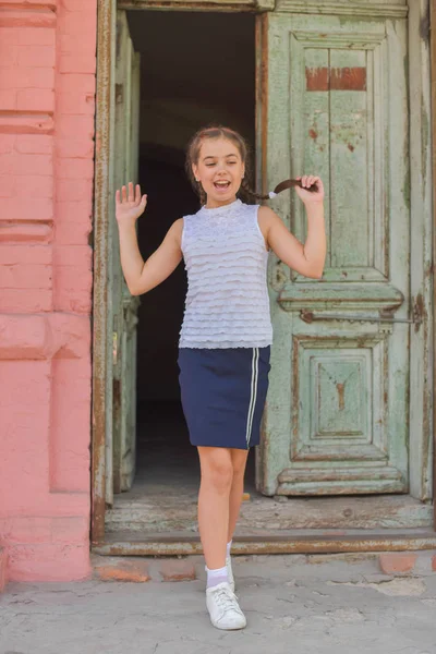 Primer plano retrato de pequeña niña hermosa y elegante cerca de la pared de ladrillo rojo como fondo — Foto de Stock