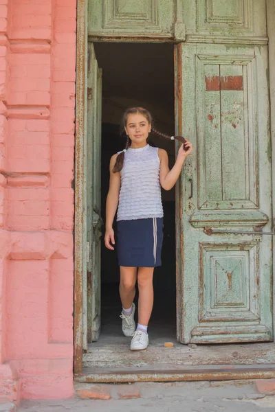 Primer plano retrato de pequeña niña hermosa y elegante cerca de la pared de ladrillo rojo como fondo — Foto de Stock