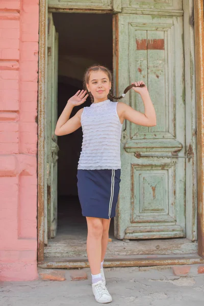 Primer plano retrato de pequeña niña hermosa y elegante cerca de la pared de ladrillo rojo como fondo — Foto de Stock