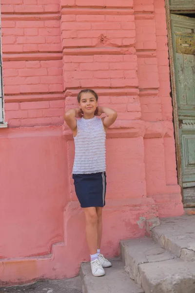 Primer plano retrato de pequeña niña hermosa y elegante cerca de la pared de ladrillo rojo como fondo — Foto de Stock