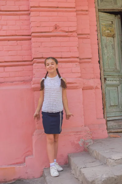 Primer plano retrato de pequeña niña hermosa y elegante cerca de la pared de ladrillo rojo como fondo — Foto de Stock