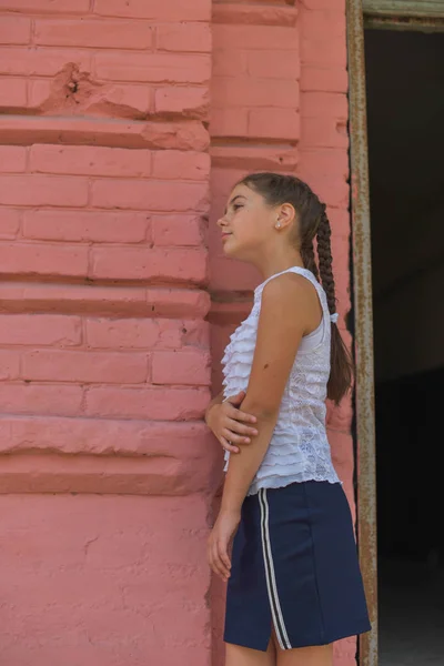 Primer plano retrato de pequeña niña hermosa y elegante cerca de la pared de ladrillo rojo como fondo — Foto de Stock