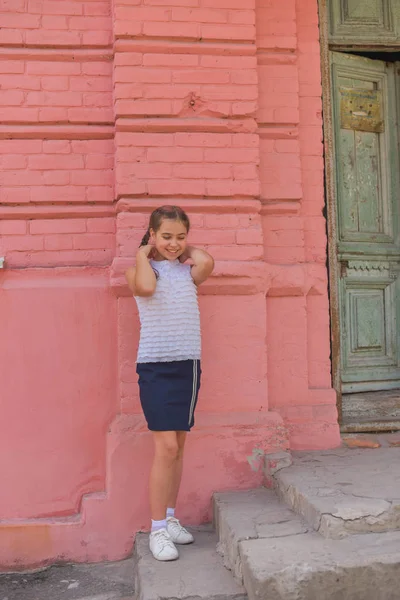 Portrait en gros plan de petite belle fille élégante enfant près du mur de briques rouges comme fond — Photo