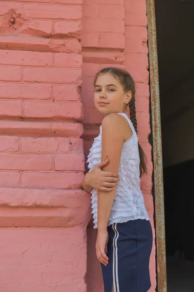 Close up portrait of little beautiful stylish kid girl near red brick wall as background — Stock Photo, Image