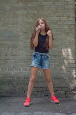 Tuğla duvar arka plan üzerinde mikrofon ile güzel küçük kız