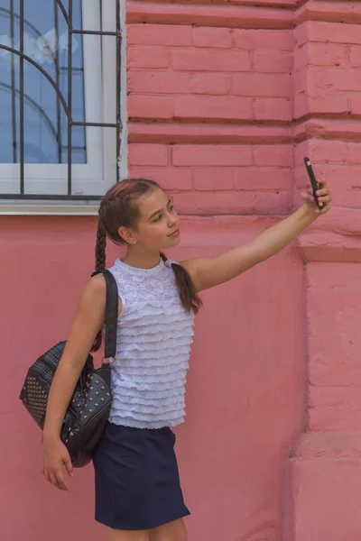 Portrait en gros plan de petite belle fille élégante enfant près du mur rouge comme fond — Photo