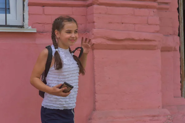 Portrait en gros plan de petite belle fille élégante enfant près du mur rouge comme fond — Photo