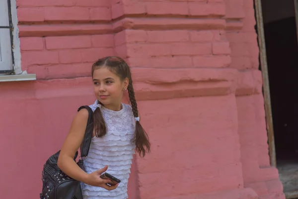 Närbild porträtt av lilla vackra snygga Kid Girl nära Red Wall som bakgrund — Stockfoto