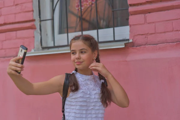 Portrait en gros plan de petite belle fille élégante enfant près du mur rouge comme fond — Photo