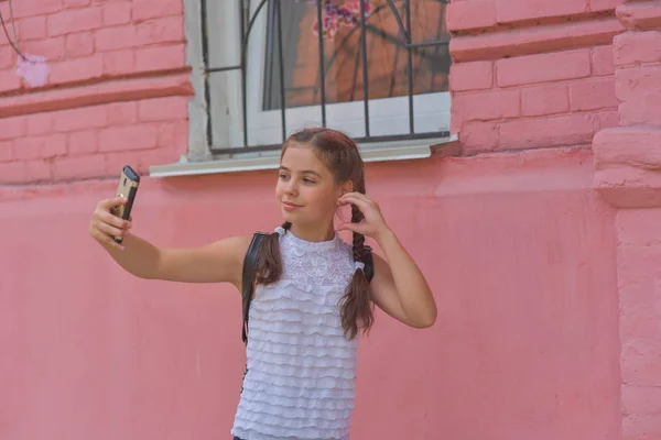 Portrait en gros plan de petite belle fille élégante enfant près du mur rouge comme fond — Photo