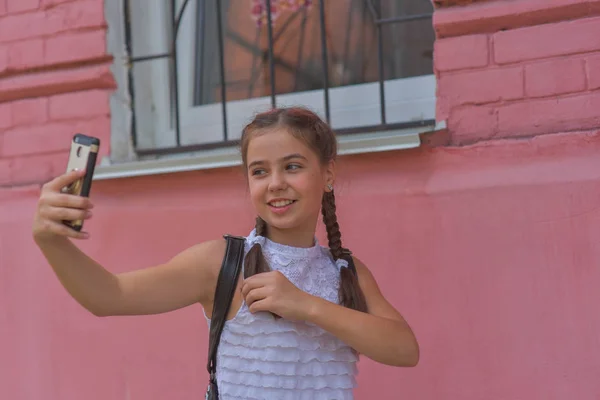 배경으로 빨간 벽 근처 작은 아름다운 세련된 아이 소녀의 초상화를 닫습니다 — 스톡 사진
