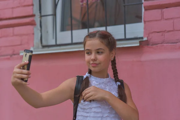 Portrait en gros plan de petite belle fille élégante enfant près du mur rouge comme fond — Photo