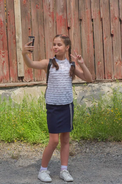 Portrait en gros plan de petite belle fille élégante enfant près du mur rouge comme fond — Photo