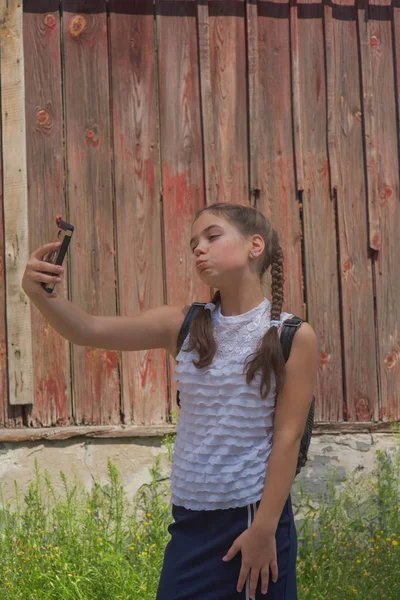 Portrait en gros plan de petite belle fille élégante enfant près du mur rouge comme fond — Photo