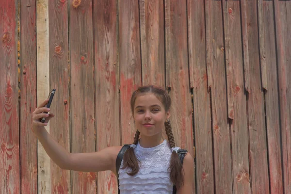 Primer plano retrato de pequeña niña hermosa y elegante cerca de la pared roja como fondo —  Fotos de Stock