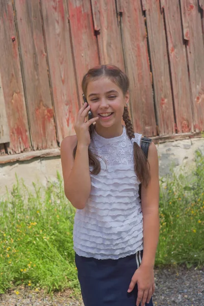 Close up portrait of little beautiful stylish kid girl near red wall as background — Stock Photo, Image