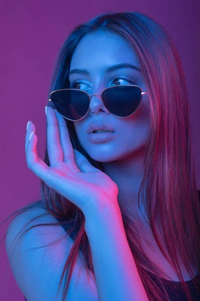 Ritratto di ragazza con gli occhiali da sole. Modello girato in studio con filtri a colori. Ritratto, moda, bellezza, bagliore . — Foto Stock