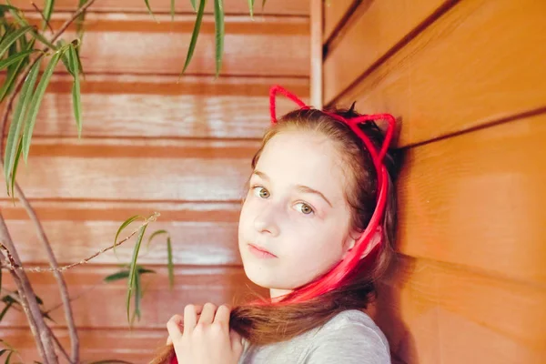 Menina criança mostrar sorriso, na cabeça uma borda na forma de orelhas de gato, retrato . — Fotografia de Stock