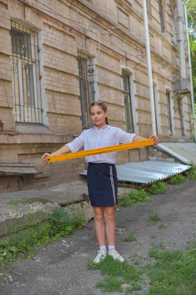 Colegiala de primaria de pie junto a la puerta de la escuela — Foto de Stock